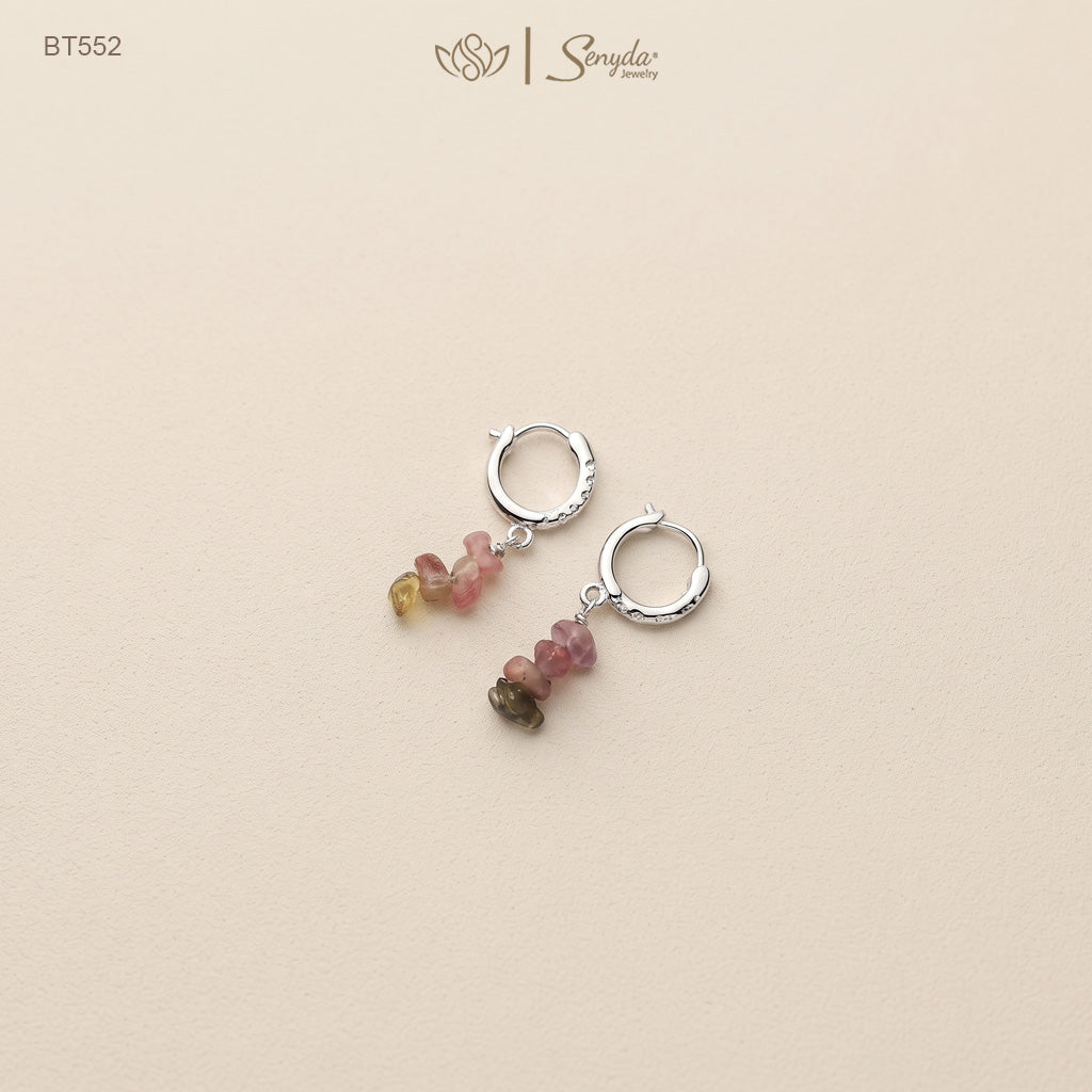 Pair of sterling silver huggie hoop earrings with pink, green and yellow tourmaline chip dangles on a beige background