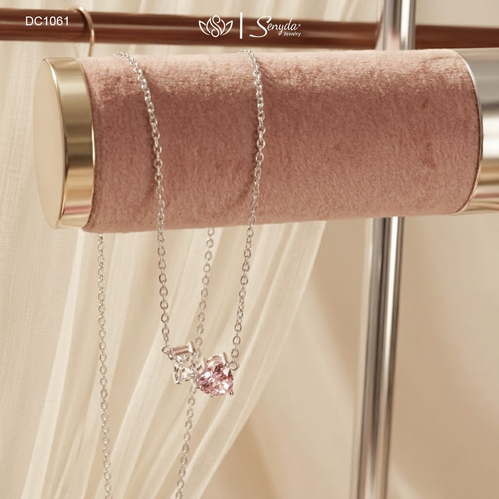 Dainty Toi et Moi necklace featuring a pastel pink heart gem paired with a clear emerald-cut cubic zirconia stone on a fine silver chain.