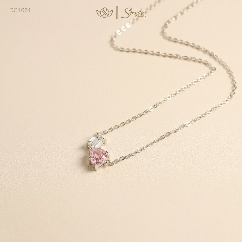 Dainty Toi et Moi necklace featuring a pastel pink heart gem paired with a clear emerald-cut cubic zirconia stone on a fine silver chain.