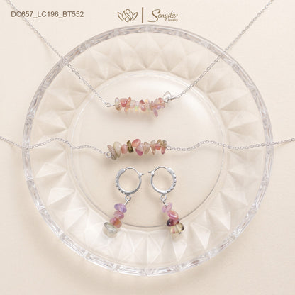 Matching tourmaline jewelry set: chip bar necklace, chip bracelet and huggie hoop dangle earrings on a glass plate