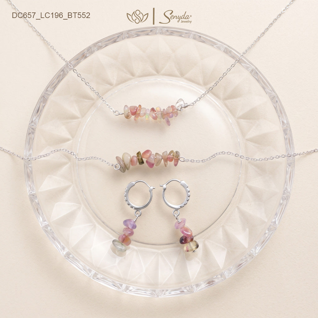 Matching tourmaline jewelry set: chip bar necklace, chip bracelet and huggie hoop dangle earrings on a glass plate