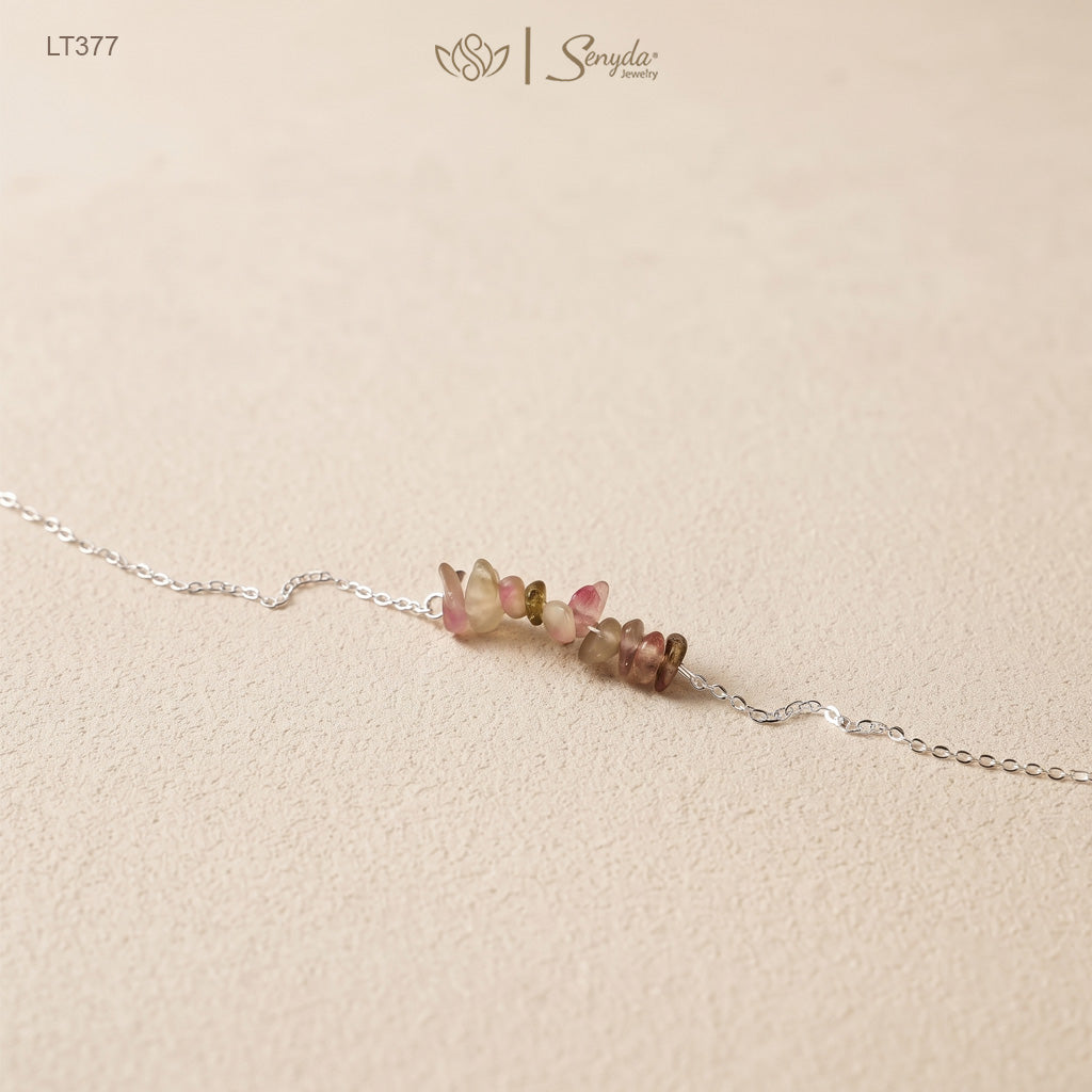 Close-up of tourmaline chip bar bracelet with pink and green watermelon-toned stones on a fine sterling silver chain
