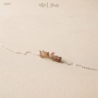 Close-up of tourmaline chip bar bracelet with pink and green watermelon-toned stones on a fine sterling silver chain