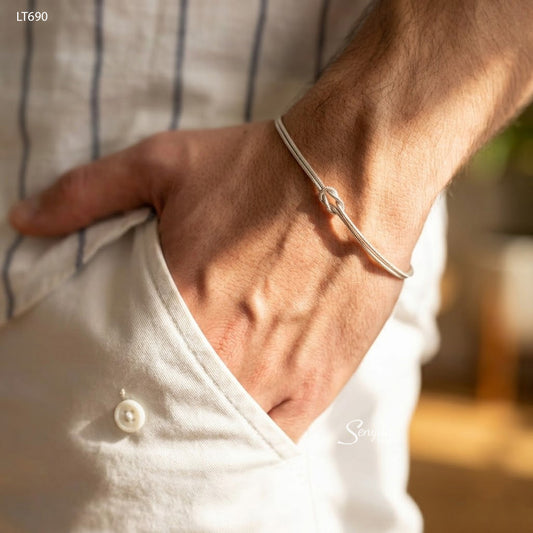 Man wearing a sterling silver double snake chain love knot bracelet with his hand in his pocket