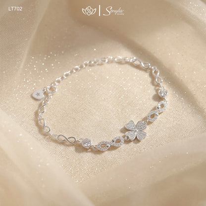 Sterling silver four leaf clover bracelet with pavé cubic zirconia heart leaves and infinity links on shimmering fabric