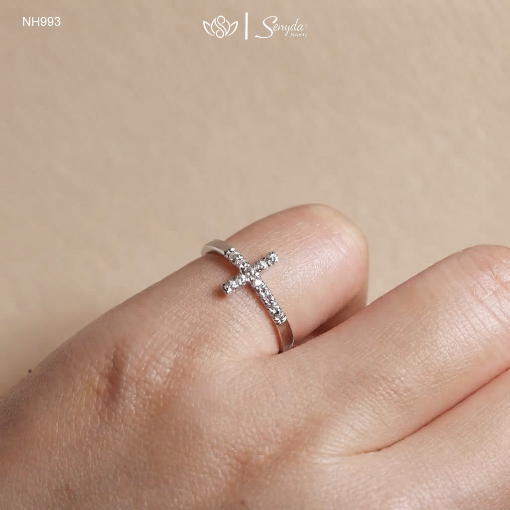 Hand wearing a dainty sideways cross ring with sparkling cubic zirconia on the index finger
