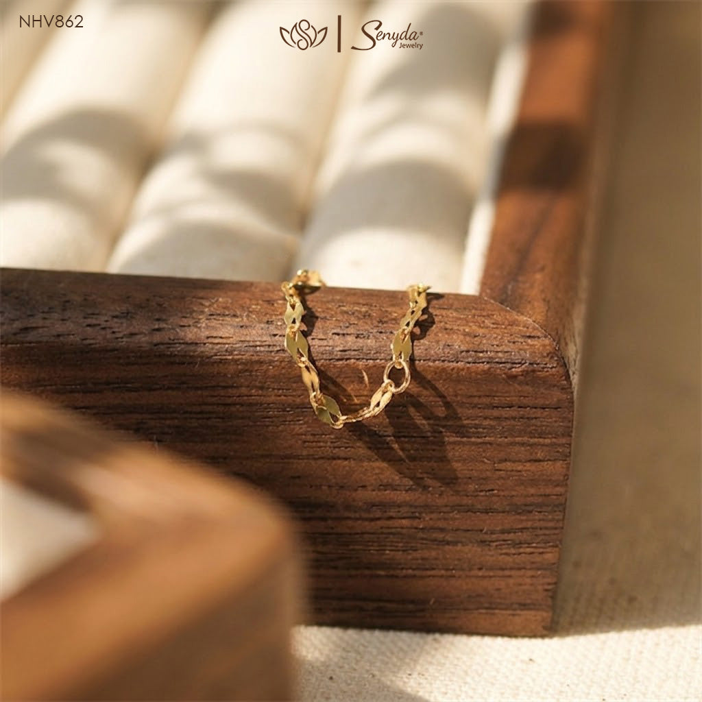 Dainty gold sequin chain ring featuring flat mirror disc links arranged in a flexible eternity loop on a wooden display.