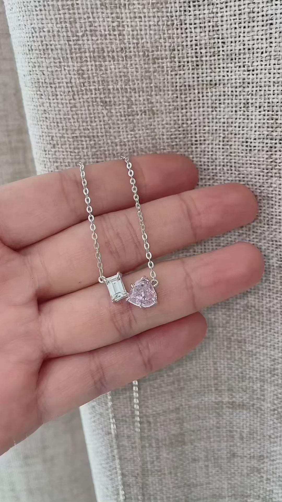 Dainty Toi et Moi necklace featuring a pastel pink heart gem paired with a clear emerald-cut cubic zirconia stone on a fine silver chain.